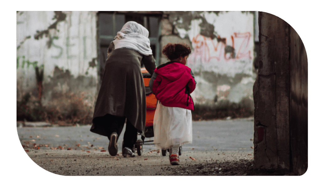 Una mujer con velo y una niña caminando por la calle.