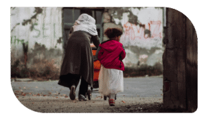 Una mujer con velo y una niña caminando por la calle.